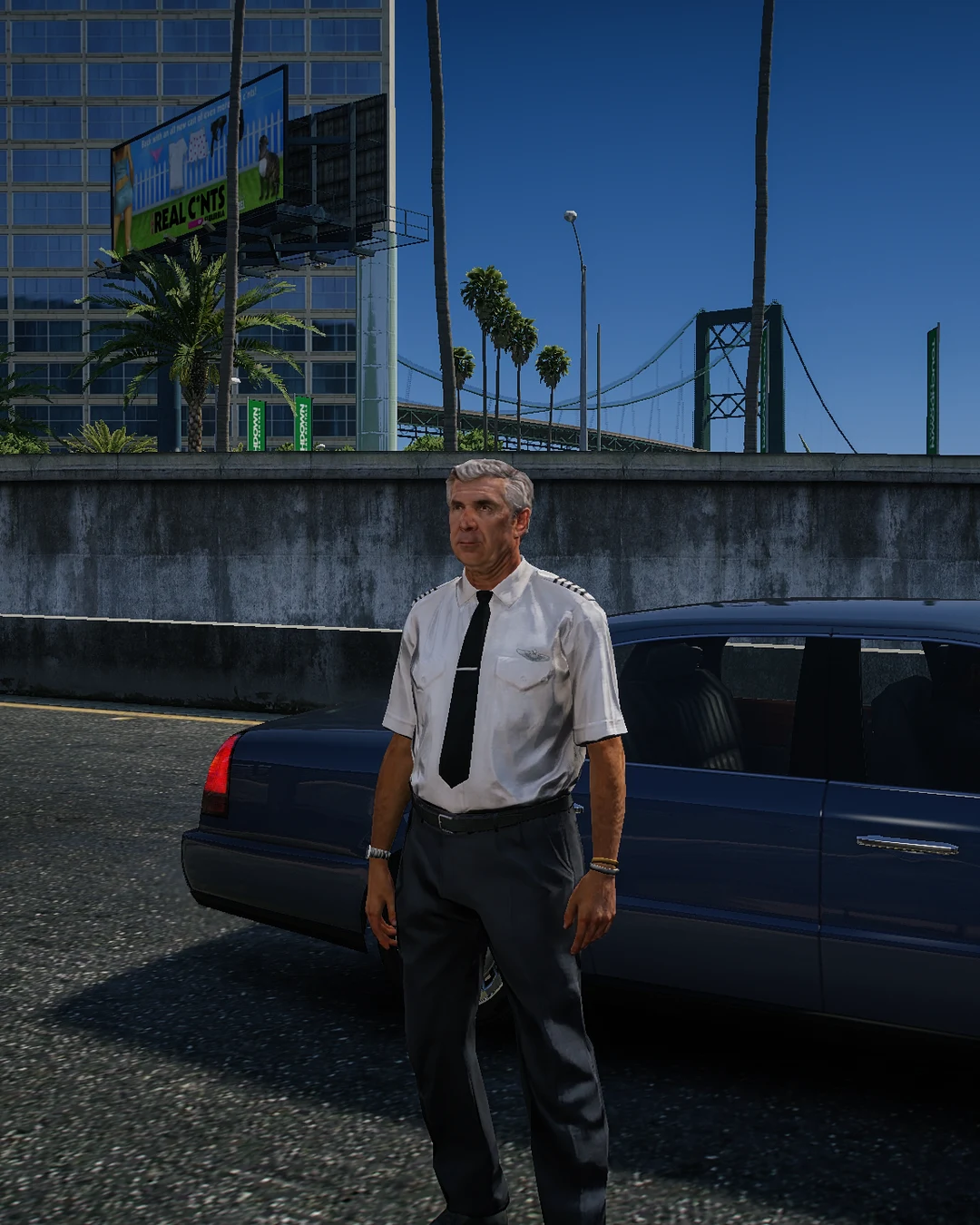 A pilot in uniform waiting for a ride at the airport.